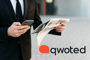 Business person in suit holding open magazine or publication in hand with a “qwoted” logo