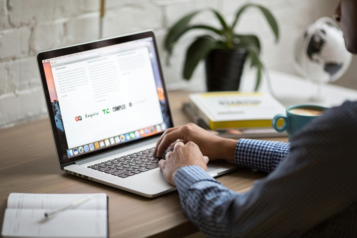 Founder drafting a brand launch press release on a laptop, with media outlet logos visible on the screen