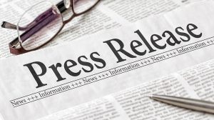 Press Release vs News Release: Differences, Use Cases & Examples Newspaper headline reading "Press Release" with eyeglasses and a silver pen resting on top