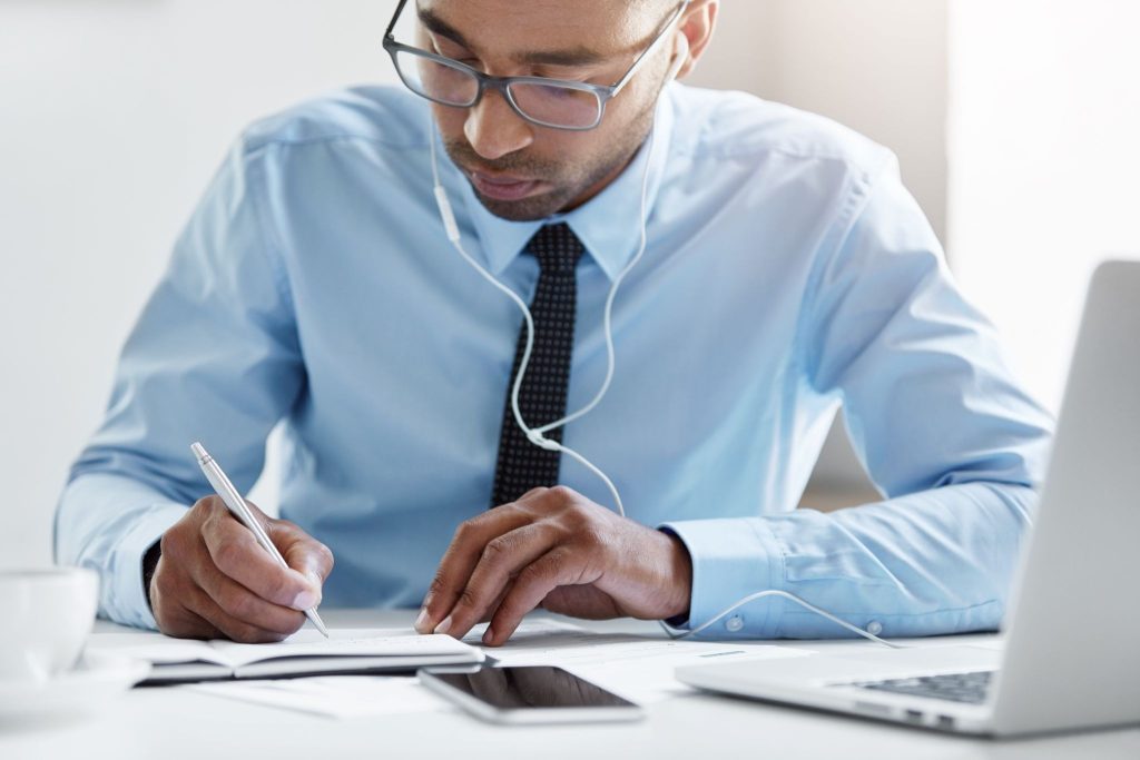 A business professional drafting a press release document at an office desk.