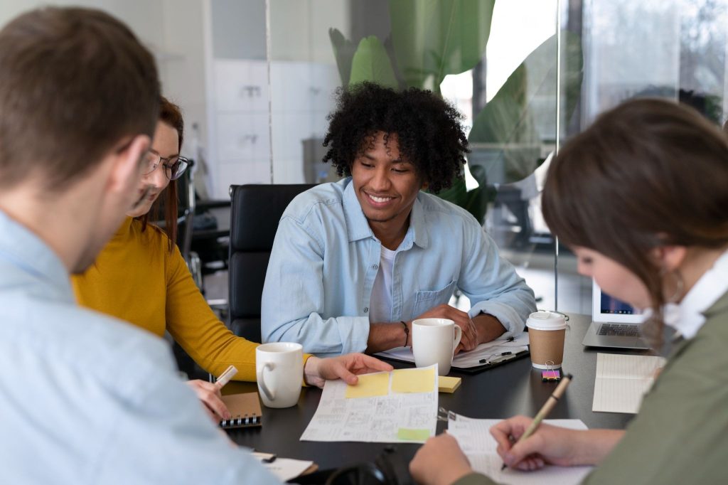 A marketing team reviewing a content calendar and planning announcement timing during a meeting.