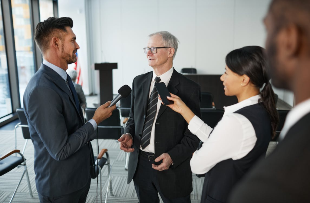 Executive being interviewed by journalists with microphones after announcing a new product or service launch.
