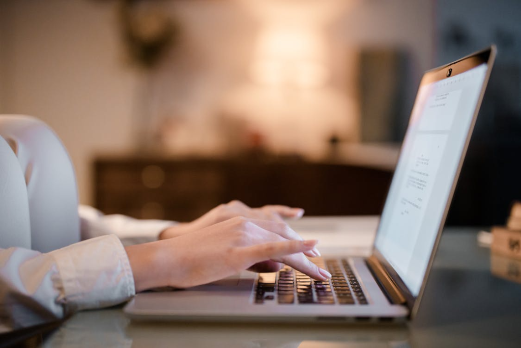 Writer typing on a laptop while editing a piece of content for a journalistic-style article.