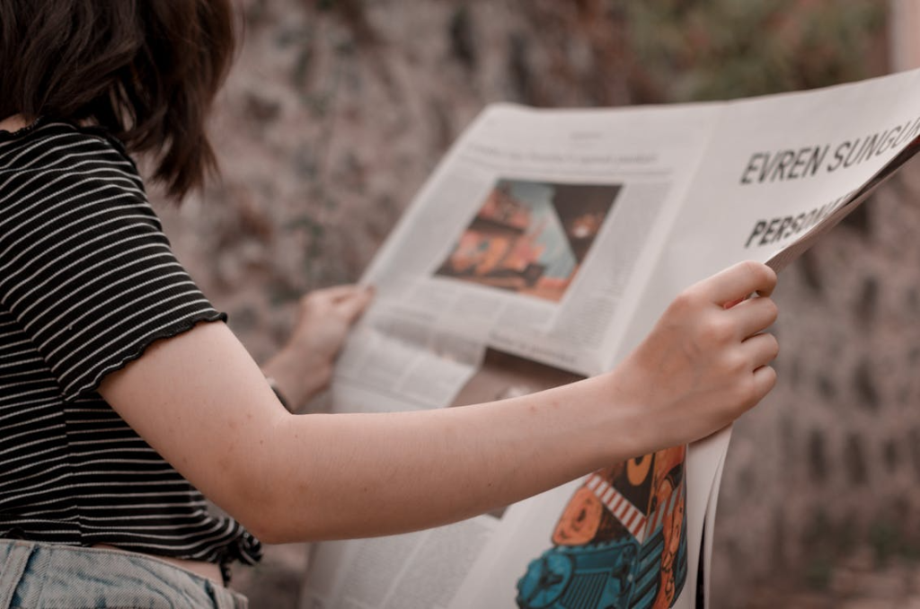 Person reading a newspaper, a classic example of content written in a journalistic tone.